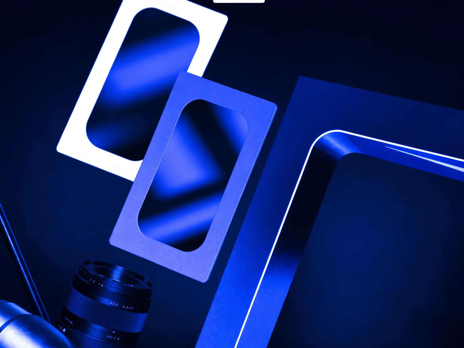 Photography expertise visual with a premium camera lens, framed photo prints and studio lighting in deep blue and white